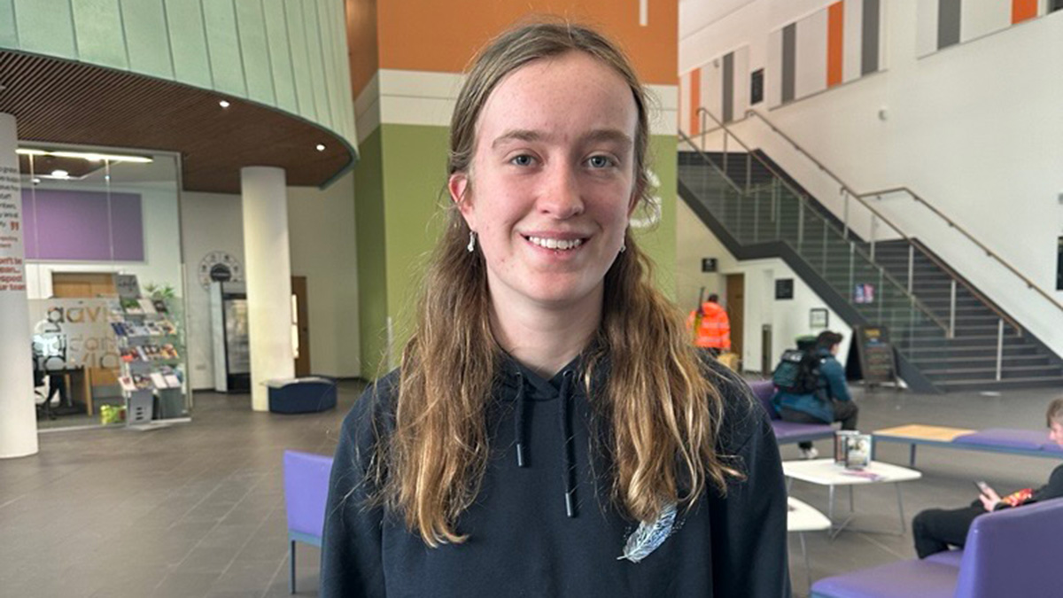Female student Ellie Moore standing in a college campus buidling Female student Ellie Moore standing in a college campus buidling