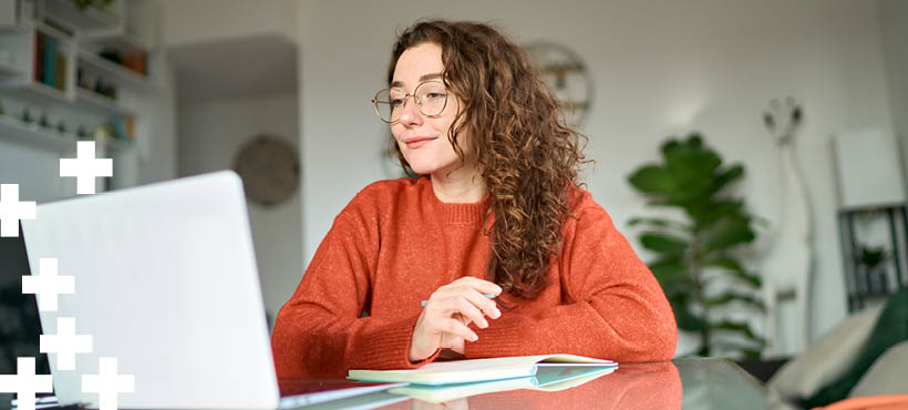 Student sat at a desk working on a laptop Student sat at a desk working on a laptop