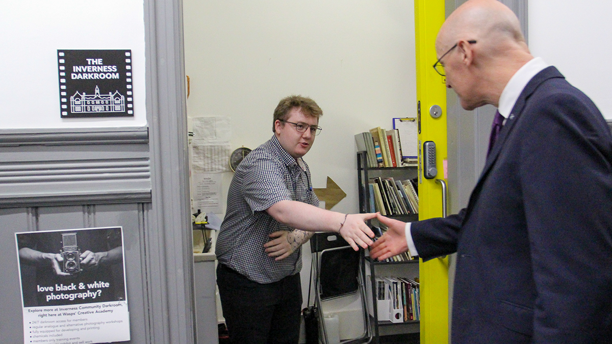 student Daniel Ferries shaking hands with First Minister John Swinney