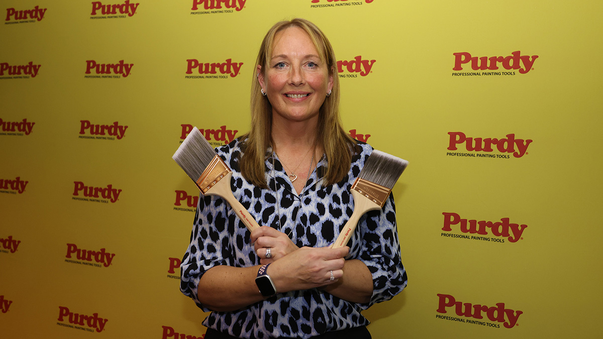 lecturer Mo Turner holding two golden paint brush award lecturer Mo Turner holding two golden paint brush award
