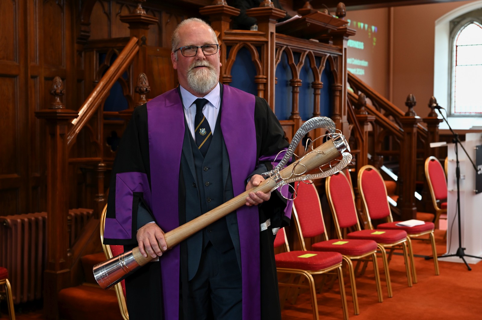 Neil Stewart holding a graduation mace