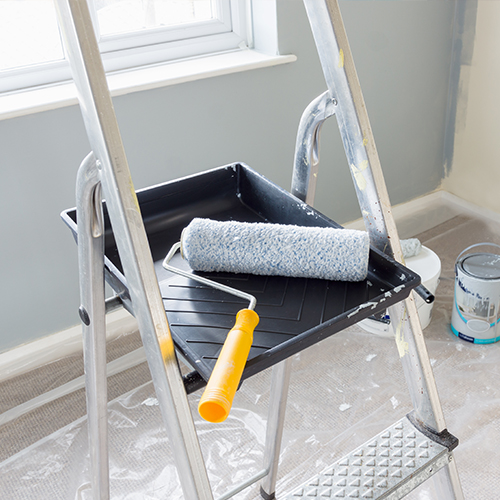 Paint roller and tray on top of step ladder