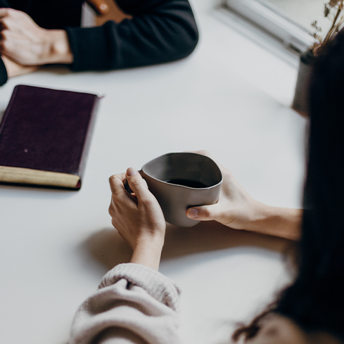 Person holding a mug on a table